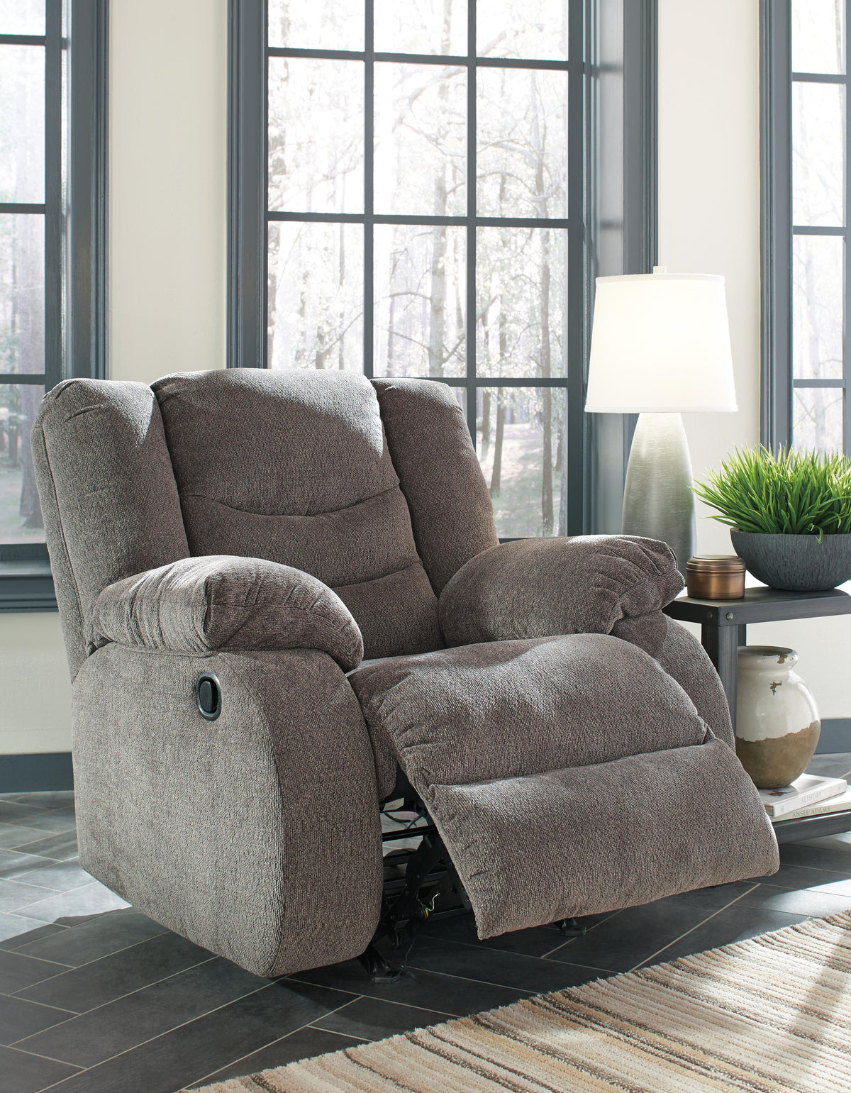 Gray fabric reclining chair with plush cushions in a modern living room setting