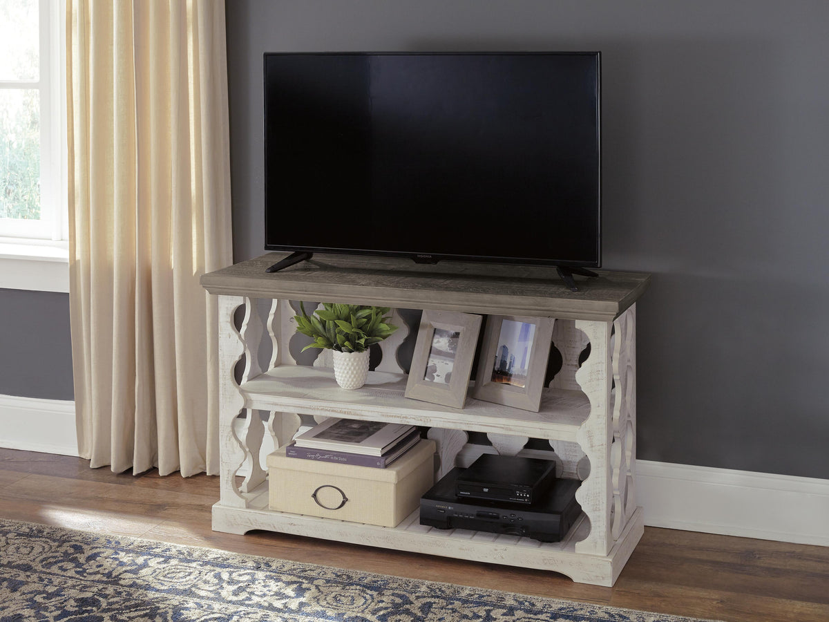 White farmhouse TV stand with open shelving and wood top in living room setting
